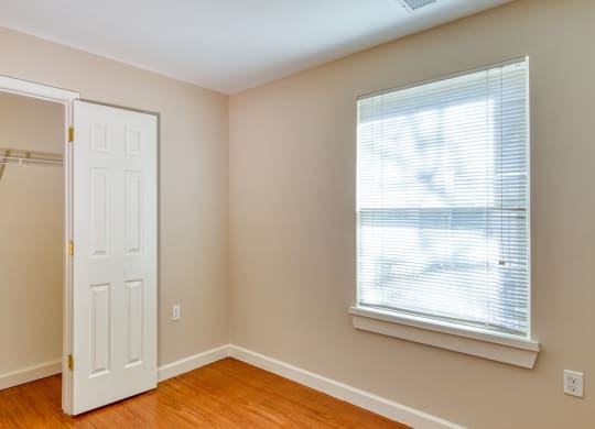 an empty bedroom with a closet and a window and a white door at North Market South Carroll, Frederick, 21701