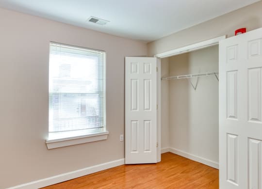 an empty bedroom with a closet and a window and a door at North Market South Carroll, Frederick, MD