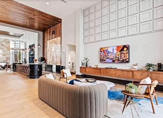 Clubhouse lounge space with couch and tv at Preston Ridge Apartments in Cary, NC.