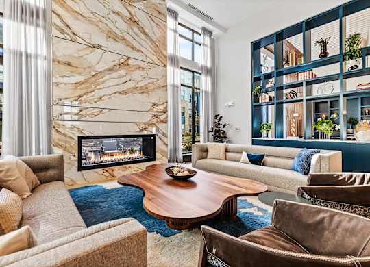 Clubhouse living room with a brown sofa and a wooden coffee table at Preston Ridge Apartments in Cary, NC.