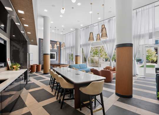 A modern dining area with a long table surrounded by chairs.