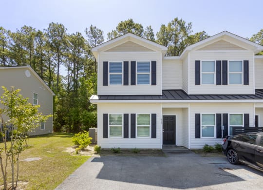 the front of the house with a car in the driveway and trees in the background  at Waverly Place, South Carolina
