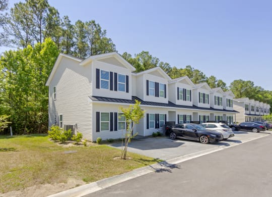 a row of houses with cars parked in front of them  at Waverly Place, North Charleston