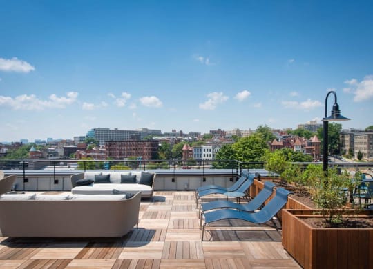 a rooftop terrace with couches and chairs and a view of the city at Reed Row, Washington, 20009