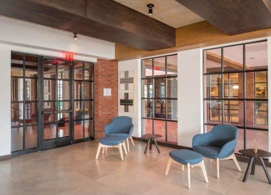 a lobby with blue chairs and glass doors at Reed Row, Washington, Washington DC