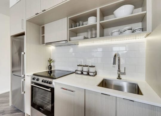 a white kitchen with a sink and a refrigerator at Reed Row, Washington, DC