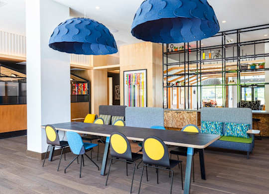 a dining room with blue chairs and a long table with chairs at The Chase at Bryant Street, Washington, DC