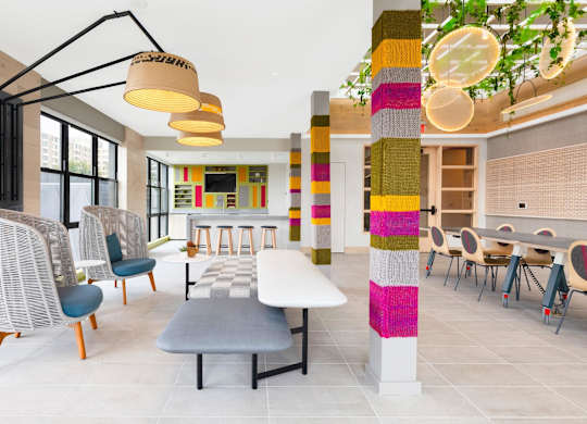 a rendering of a lobby with tables and chairs and a colorful column at The Chase at Bryant Street, District of Columbia