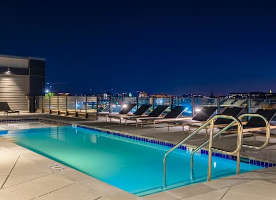 a swimming pool on the roof of a building at night at Coda at Bryant Street, Washington, 20002