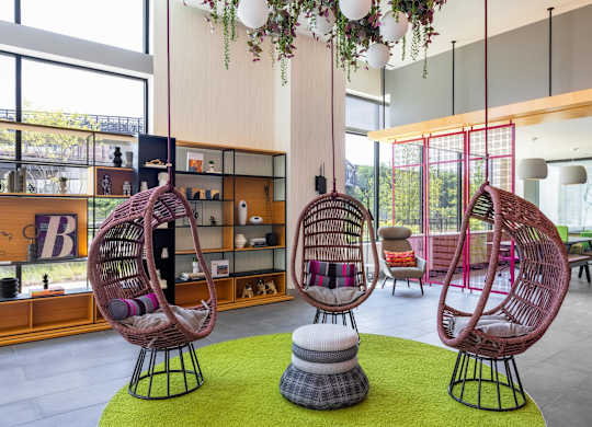 a lobby with two rattan chairs and a green rug at Coda at Bryant Street, Washington, DC