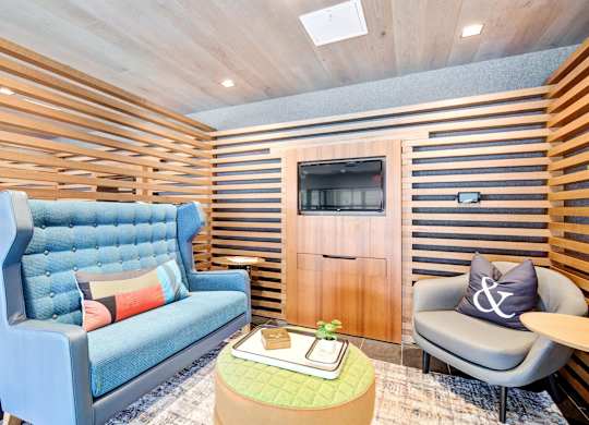 a living room with a blue couch and a tv at Coda at Bryant Street, Washington DC