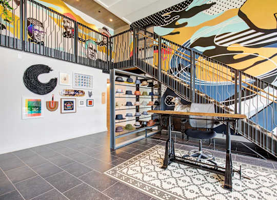 a home office with a desk and a staircase with art on the wall at Coda at Bryant Street, Washington, DC