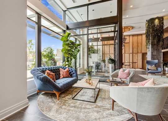 a living room with a blue couch and a large window at Coda at Bryant Street, Washington