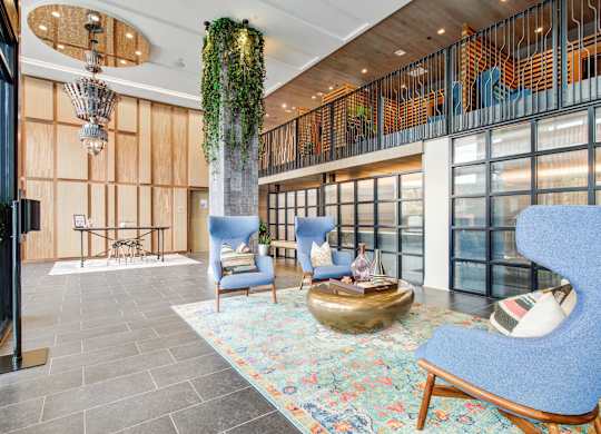 a lobby with blue chairs and a gold sculpture in the middle at Coda at Bryant Street, Washington, DC 20002