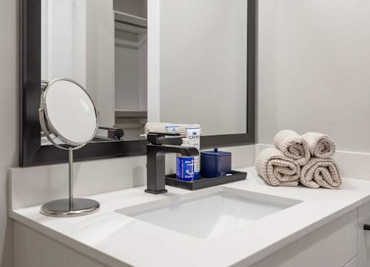 a bathroom with a sink and a mirror and towels at Coda at Bryant Street, Washington, DC