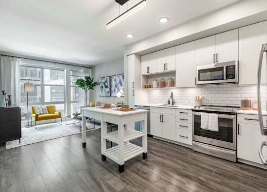 a kitchen with white cabinets and stainless steel appliances at Coda at Bryant Street, Washington
