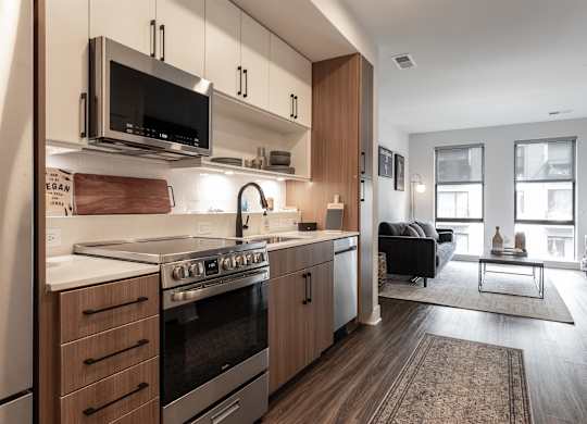 a kitchen with wooden cabinets and a stove and a microwave at Coda at Bryant Street, Washington, 20002