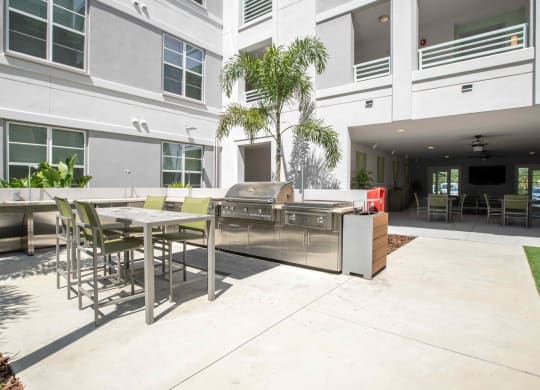 a patio with a grill and tables and chairs at Delamarre at Celebration, Florida, 34747