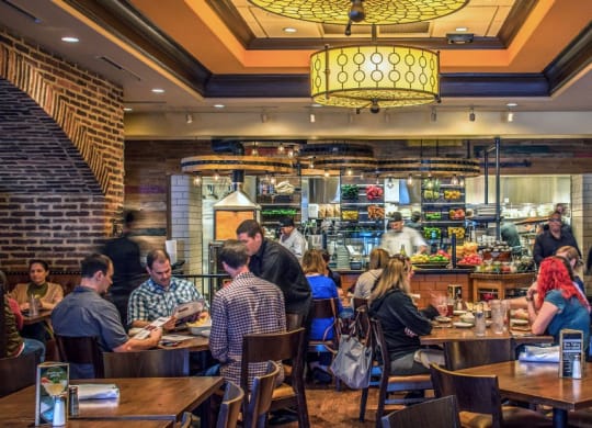 a group of people sitting at tables in a restaurant at Vyne One Loudoun, Virginia