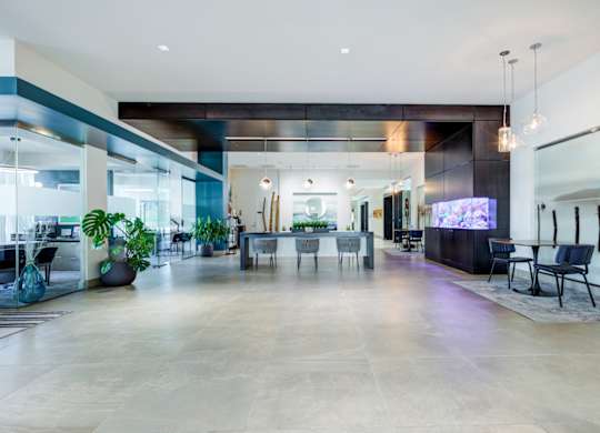 A spacious lobby with a large marble floor and modern furniture.