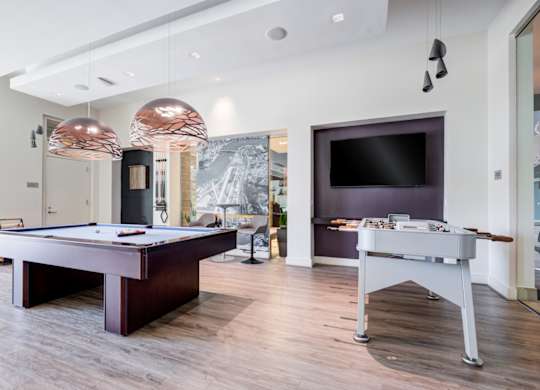A room with a pool table and a television.