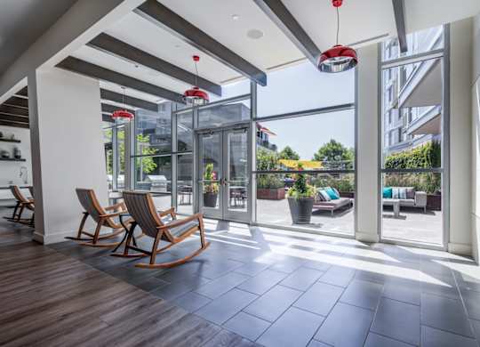 A modern living room with wooden floors and a glass door leading to a balcony.