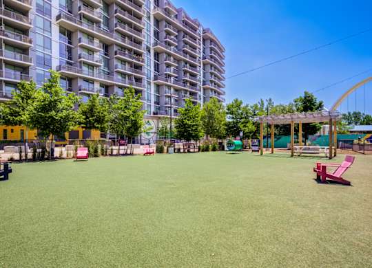 A park with a green lawn and a playground.