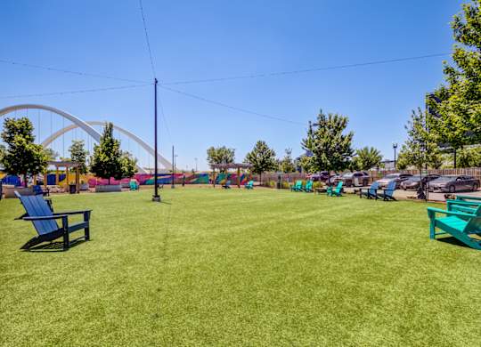 A park with a blue bench and a green bench in the foreground.