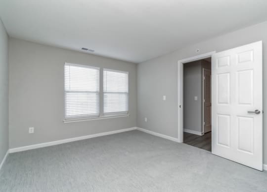 an empty bedroom with a white door and window at The Fields at Lorton Station, Lorton, VA