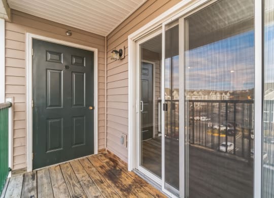 the front porch of a home with a black door and a balcony at The Fields at Lorton Station, Lorton, 22079