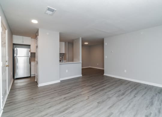 an empty living room and kitchen with a refrigerator and at The Fields at Lorton Station, Lorton, 22079