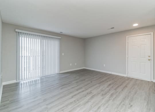 an empty living room with a large window and a door at The Fields at Lorton Station, Lorton, Virginia
