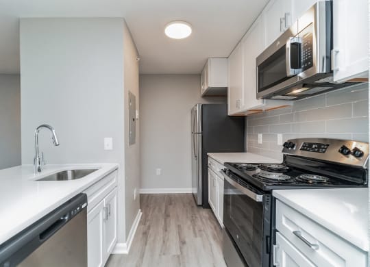 an empty kitchen with white cabinets and stainless steel appliances at The Fields at Lorton Station, Virginia, 22079