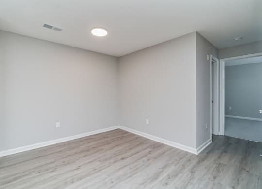 an empty living room with wood floors and grey walls at The Fields at Lorton Station, Lorton, VA