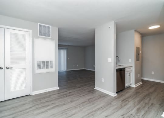 an empty living room with white doors and a kitchen at The Fields at Lorton Station, Lorton, 22079