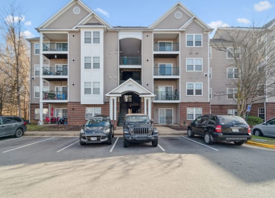 an apartment building with cars parked in front of it at The Fields at Lorton Station, Lorton, Virginia