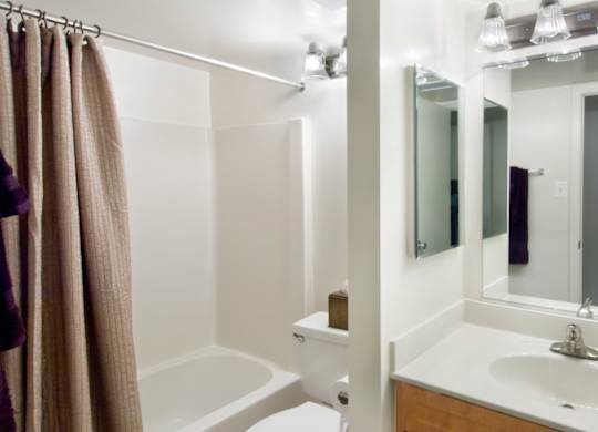A bathroom with a white sink and a white tub.