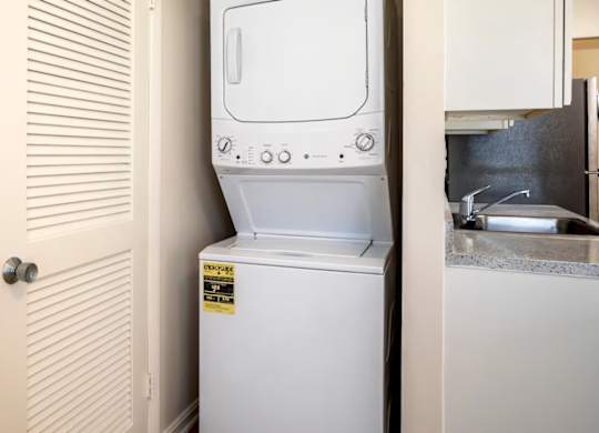 A white washing machine is in a small room.