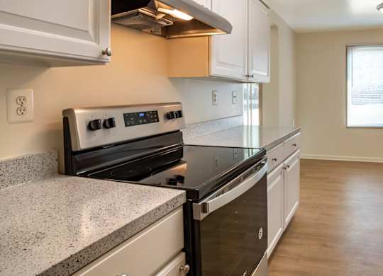 A kitchen with a stove top oven and a refrigerator.