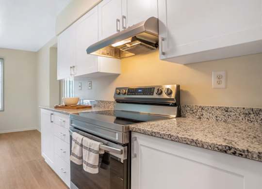 A kitchen with a stove top oven and a window.