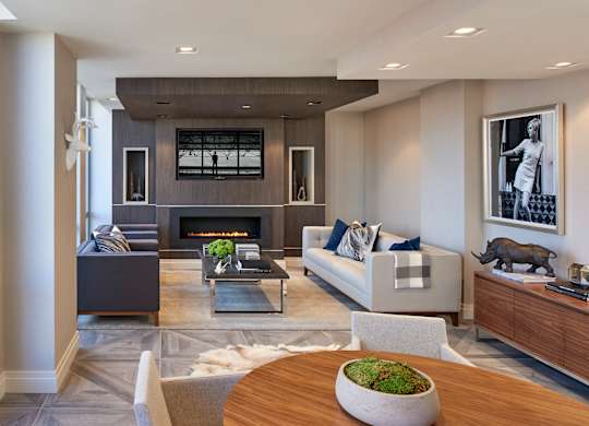 A modern living room with a fireplace and a large painting on the wall.