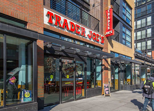 A Trader Joe's storefront with a person walking by.