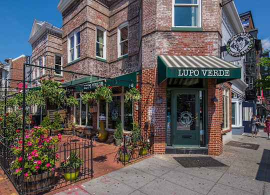 A brick building with a green awning that says