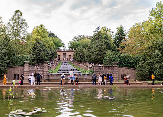 A group of people are standing on a bridge over a body of water.