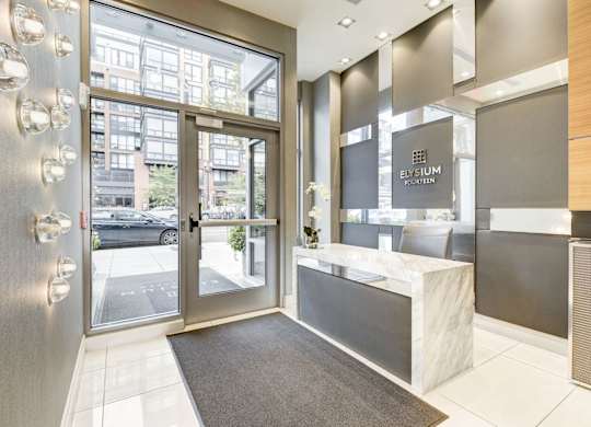 A modern front desk with a glass door leading to a balcony.