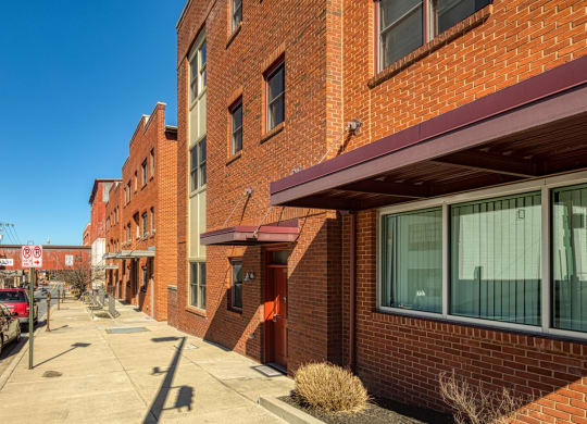 a city street with brick buildings and cars parked on the sidewalk at North Market South Carroll, Frederick, MD