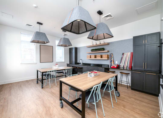 a dining room with tables and chairs and a kitchen at Fairmont at South Lake, Bowie