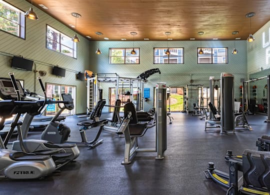 A gym with a variety of equipment including treadmills, weights, and exercise machines at Crestline Cary, Cary North Carolina