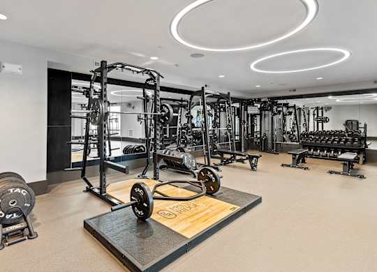 A gym with a variety of equipment including weights and machines.