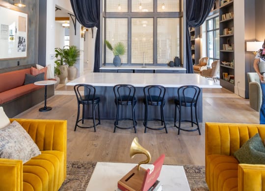 a living room with yellow couches and a table in front of a large window  at La Unión, Tampa, 33605